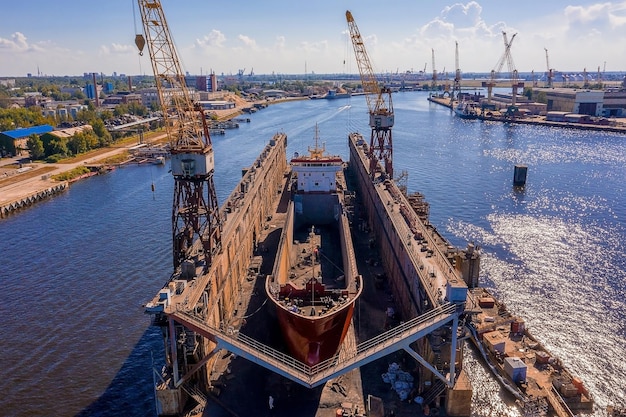 Luftaufnahme des Schiffes im schwimmenden Trockendock in Reparatur durch Sandstrahlen in Riga, Lettland.