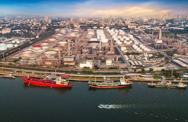 Luftaufnahme des Schifffahrtshafens und des Ölraffineries in der Stadt am Flussufer nehmen mit Drohne