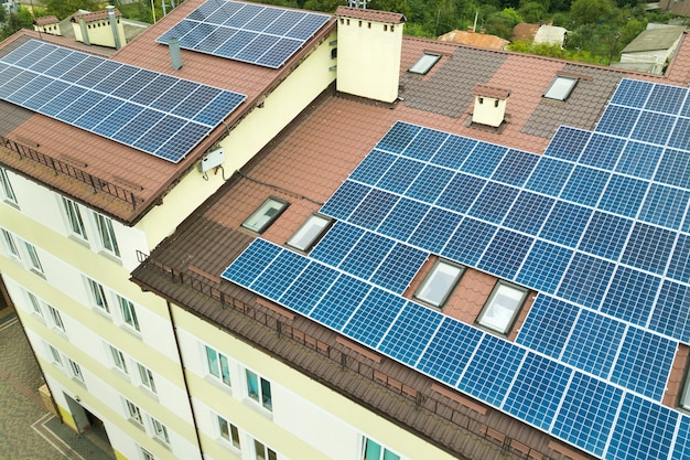 Luftaufnahme des Solarkraftwerks mit blauen Photovoltaikmodulen, die vom Dach des Wohnhauses montiert werden.