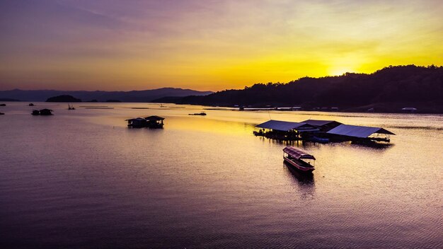 Luftaufnahme des Sonnenuntergangs mit Reservoir und Floßhaus Thailand