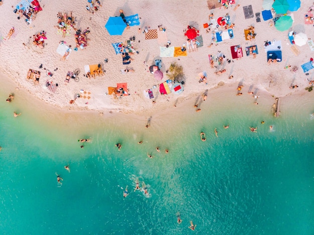 Luftaufnahme des sonnigen Sandstrandes mit blauem azurblauem Wasser