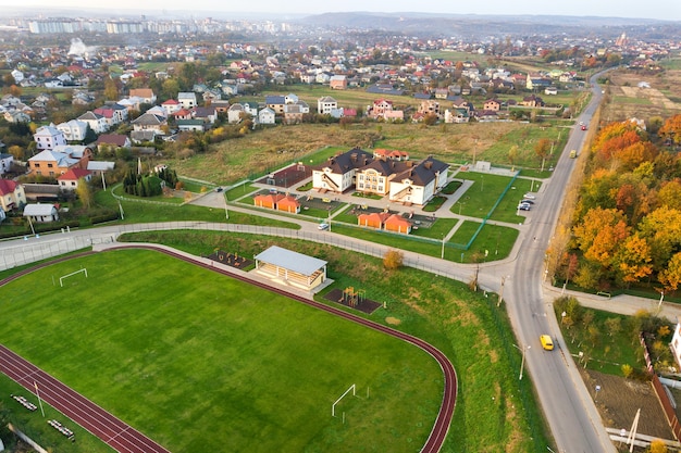 Luftaufnahme des Sportstadions mit roten Laufstrecken und grünem Gras-Fußballplatz.