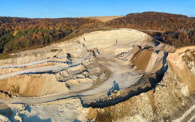 Luftaufnahme des Tagebaus von Kalksteinmaterialien für die Bauindustrie mit Baggern und Muldenkippern