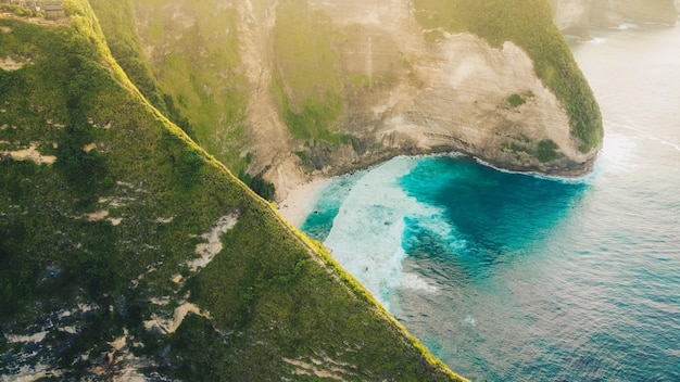 Luftaufnahme des tropischen Strandes mit hohen Klippen und blauem Meerwasser am Morgen Nusa Penida Insel Bali