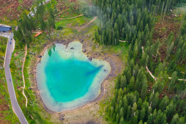 Luftaufnahme des türkisblauen Wassers des Carezza-Sees in den Alpendolomiten. Lago di Karersee in der Nähe von Tannenwald.