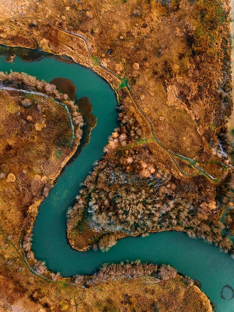 Luftaufnahme des türkisfarbenen gewundenen Flusses und des goldenen Herbstes