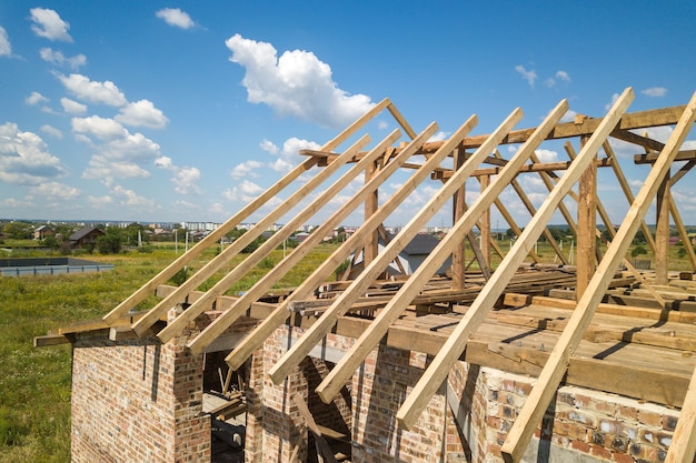 Luftaufnahme des unfertigen Hauses mit hölzerner Dachrahmenkonstruktion im Bau.