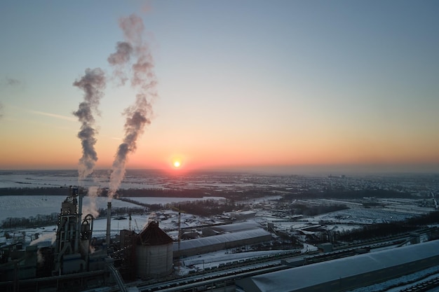 Luftaufnahme des Zementfabrikturms mit hoher Betonwerksstruktur im industriellen Produktionsbereich bei Sonnenuntergang Herstellung und globales Industriekonzept