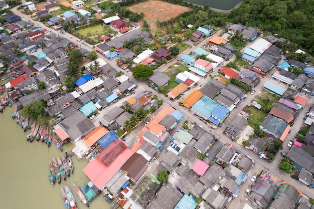 Luftaufnahme Draufsicht auf das Fischerdorf mit Fischerbooten und Hausdach am Pier in Suratthani Thailand Hochwinkelansicht