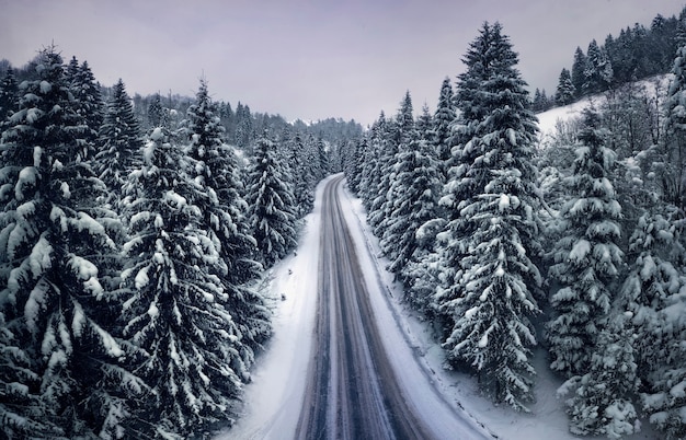 Luftaufnahme einer Bergstraße im Winterwald