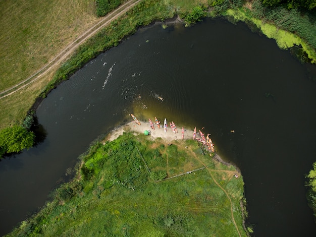 Luftaufnahme einer Gruppe von Kajaks, die an einem Sommertag auf einem Waldfluss reisen