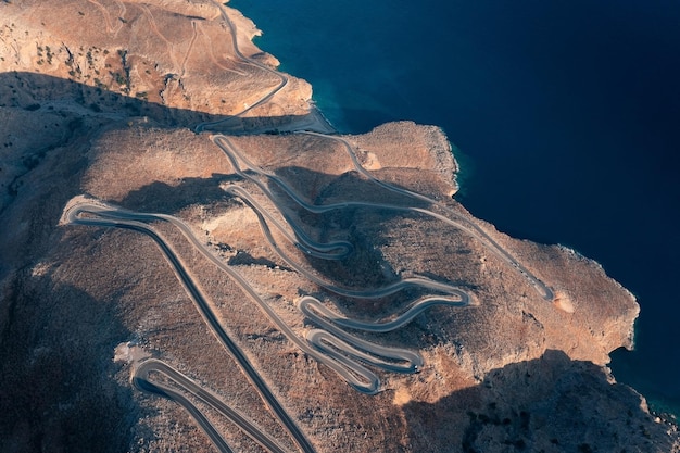 Luftaufnahme einer kurvenreichen Straße in Wüstenhügeln nahe der Küste bei Sonnenuntergang Kreta Griechenland