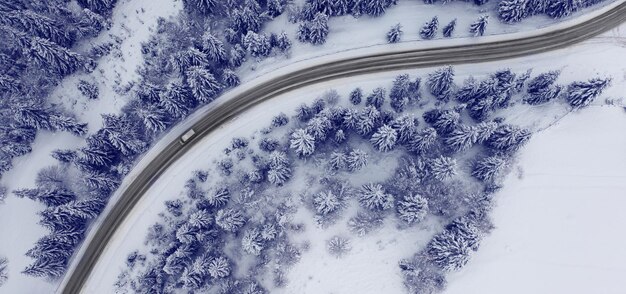 Luftaufnahme einer kurvigen Bergstraße Luftaufnahme einer kurvigen Bergstraße in Europa. Winterliche Berglandschaft. Schneebedeckte Bäume und Berghänge. Drohnenansicht.Europa.