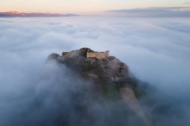 Luftaufnahme einer mittelalterlichen Burg in einem wunderschönen nebligen Sonnenuntergang Poza de la sal Burgos Spanien Hochwertige Fotografie