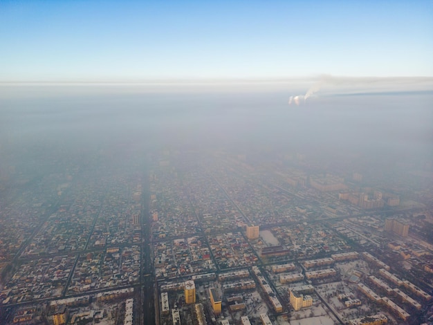 Luftaufnahme einer verschmutzten Stadt, die mit Smog bedeckt ist