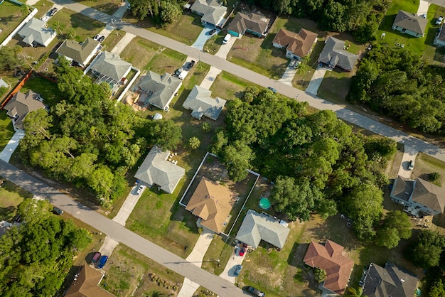 Luftaufnahme einer Vorstadtlandschaft mit Privathäusern zwischen grünen Palmen in einer ruhigen Wohngegend in Florida