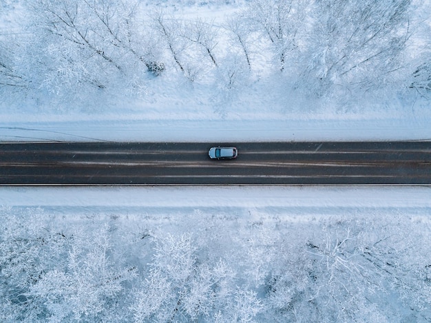 Luftaufnahme einer Winterstraße mit schneebedecktem Wald