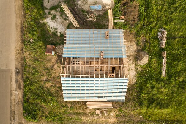 Luftaufnahme eines Backsteinhauses mit Holzdachrahmen im Bau.