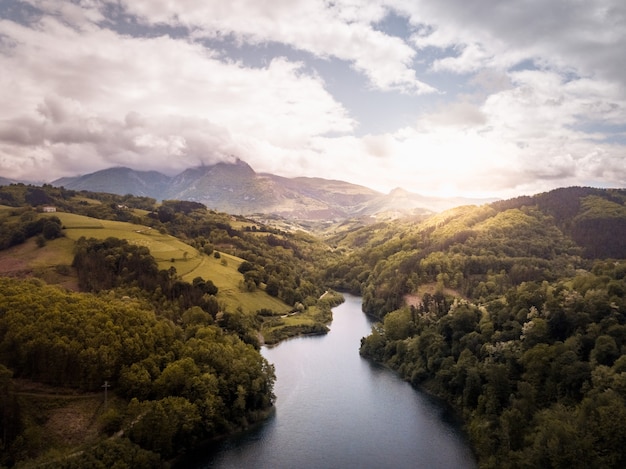 Luftaufnahme eines bergigen Flusses mit einer Straße am Rand. Berglandschaft mit Fluss