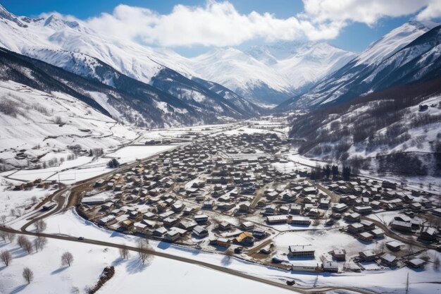 Luftaufnahme eines Dorfes, das von schneebedeckten Bergen umgeben ist