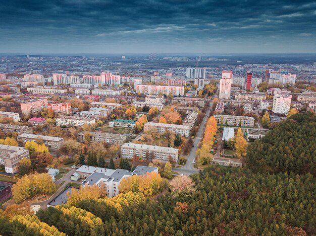 Luftaufnahme eines farbenfrohen herbstlichen Stadtparks und eines Viertels sowie eines Wohnblocks mit Gebäuden