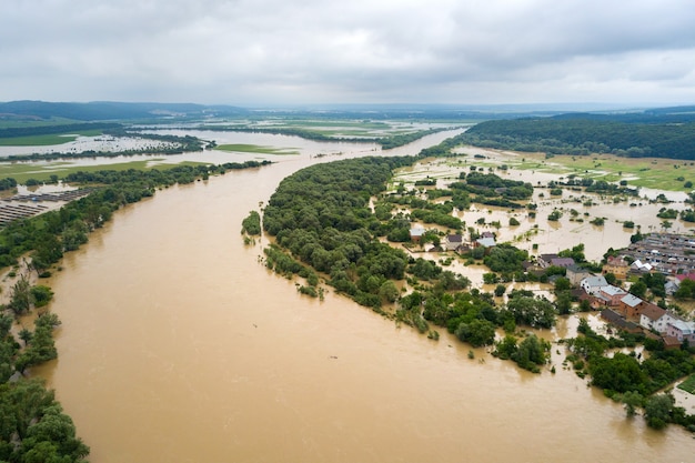 Luftaufnahme eines Flusses mit schmutzigem Wasser und überfluteten Häusern