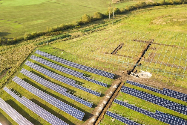 Luftaufnahme eines im Bau befindlichen Solarkraftwerks auf der grünen Wiese Montage von Schalttafeln zur Erzeugung sauberer ökologischer Energie