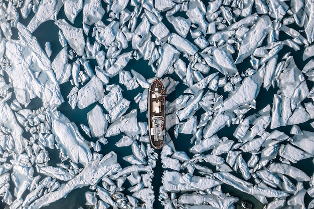 Luftaufnahme eines Schiffes inmitten eines Gletschers auf See