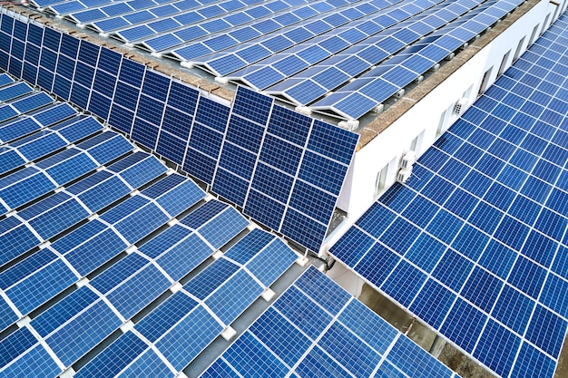 Luftaufnahme eines Solarkraftwerks mit blauen Photovoltaikplatten, die auf dem Dach eines Industriegebäudes montiert sind, um grünen ökologischen Strom zu erzeugen Produktion eines nachhaltigen Energiekonzepts
