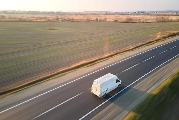 Luftaufnahme eines unscharfen, sich schnell bewegenden Lastwagens, der auf der Autobahn fährt und Güter transportiert. Liefertransport- und Logistikkonzept