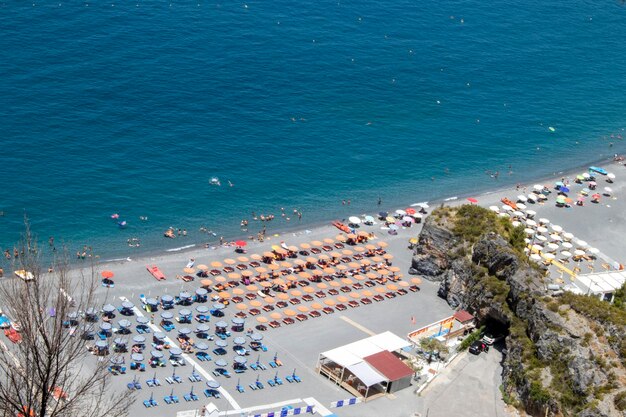 Luftaufnahme eines wunderschönen weißen Sandstrandes mit türkisfarbenem Meerwasser und Sonnenschirmen. Urlaub