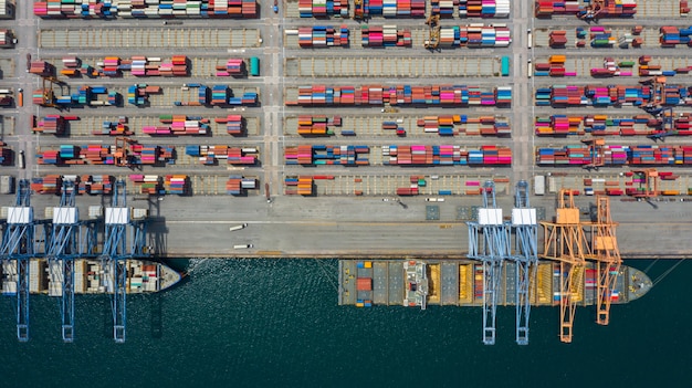 Luftaufnahme-Frachtschiffanschluß, Kran des Frachtschiffanschlußes entladend, Industriehafen der Luftaufnahme mit Behältern und Containerschiff.