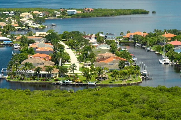 Luftaufnahme ländlicher Privathäuser in abgelegenen Vororten in der Nähe von Florida Wildlife Feuchtgebieten mit grüner Vegetation am Ufer der Meeresbucht Leben in der Nähe des Naturkonzepts