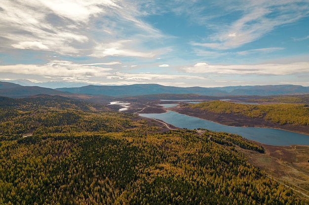 Luftaufnahme mit Blick auf die malerische Natur mit einem riesigen weiten Wald und einem fließenden Bach in der Ferne.