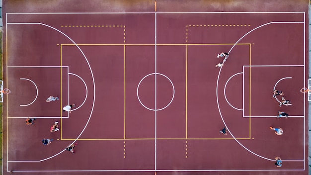 Luftaufnahme streng von oben mit der Drohne zu einem Basketballplatz mit Spielern und Ball. Sportspiel im Basketball. Draufsicht.