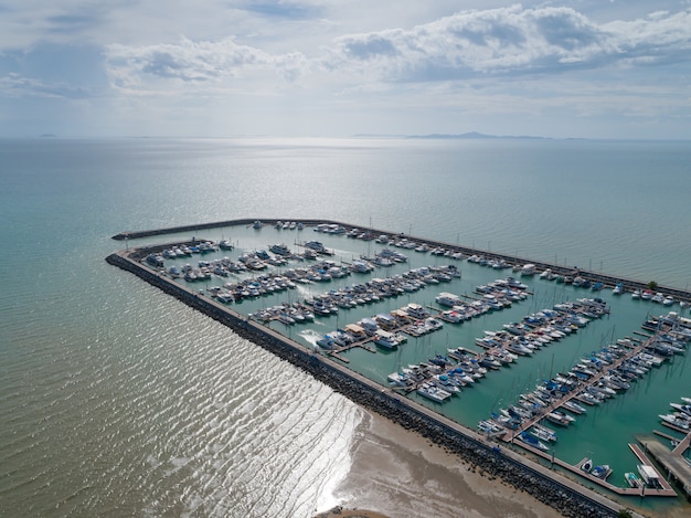 Luftaufnahme über Hafen mit Luxusyachten - Segelboothafen, viele schönen festgemachten Segeljachten im Seehafen MIT Wolken des blauen Himmels.