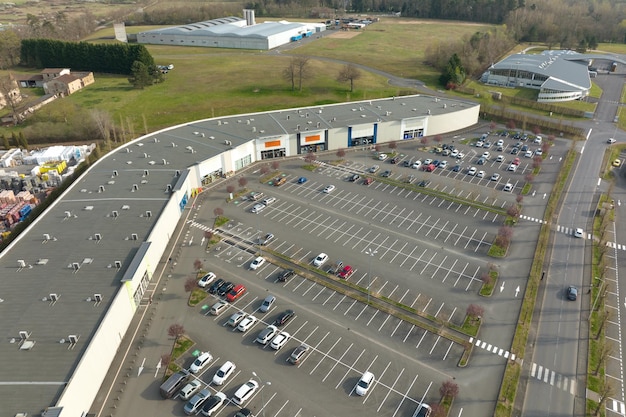 Luftaufnahme vieler bunter Autos, die auf dem Parkplatz mit Linien und Markierungen für Parkplätze und Wegbeschreibungen geparkt sind