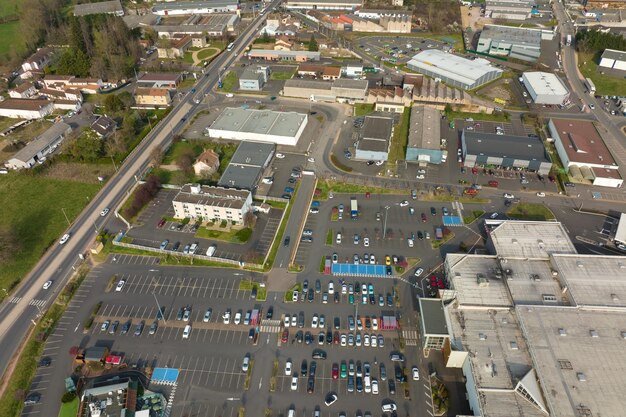 Luftaufnahme vieler bunter Autos, die auf dem Parkplatz mit Linien und Markierungen für Parkplätze und Wegbeschreibungen geparkt sind