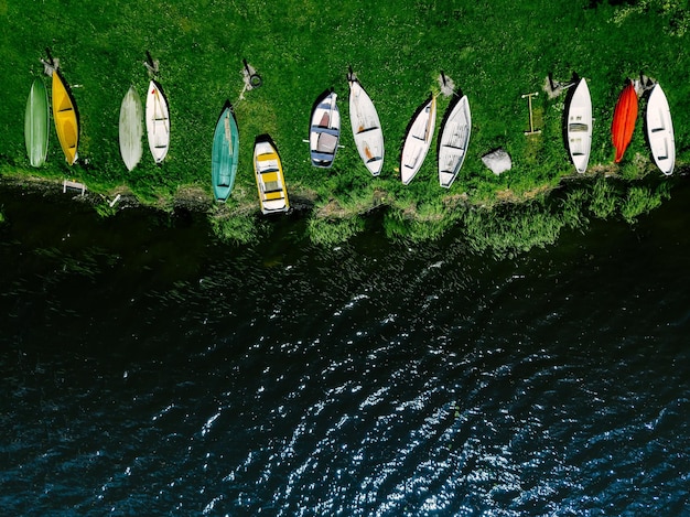 Luftaufnahme von bunten Holzbooten in einer Reihe am Ufer des Sees in Finnland