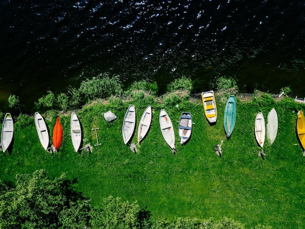 Luftaufnahme von bunten Holzbooten in einer Reihe am Ufer des Sees in Finnland