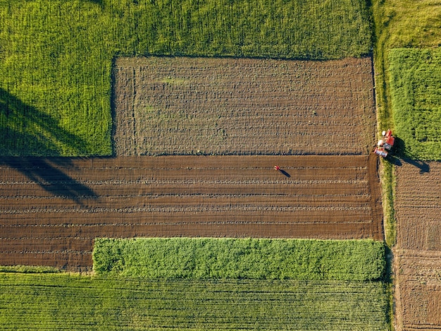 Luftaufnahme von der Drohne, eine Vogelperspektive von landwirtschaftlichen Feldern mit einer Straße durch