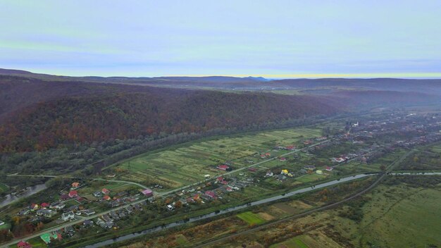 Luftaufnahme von der Höhe des schönen ländlichen Dorfes mit Häusern und Straßen auf gepflügtem Feld