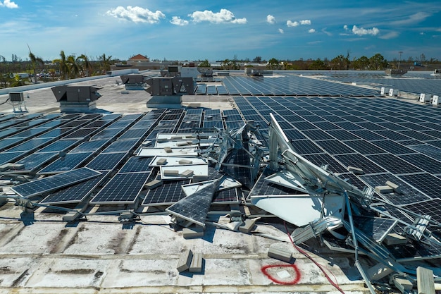 Foto luftaufnahme von durch hurrikanwind beschädigten photovoltaik-solarmodulen, die auf dem dach eines industriegebäudes montiert sind, um grünen ökologischen strom zu erzeugen folgen einer naturkatastrophe
