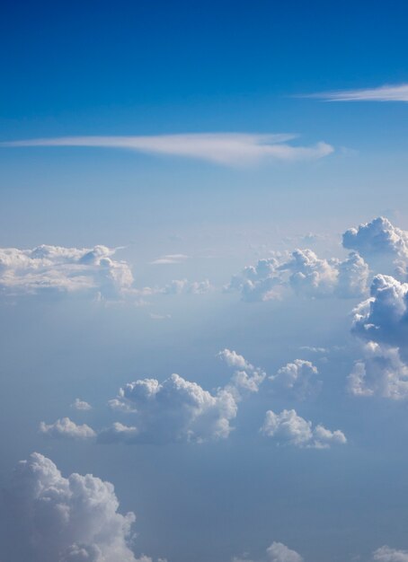 Luftaufnahme von flauschigen weißen Kumuluswolken auf einem Hintergrund von klarem blauem Himmel mit Platz für Ihren Text. Reise- und Tourismuskonzept.