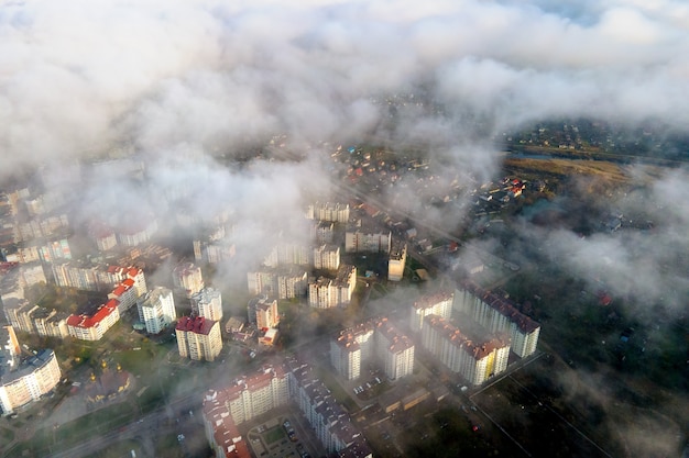 Luftaufnahme von flauschigen weißen Wolken über der modernen Stadt mit Hochhäusern.