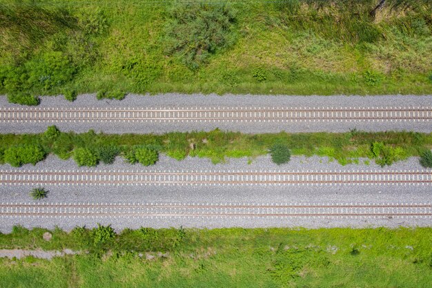 Luftaufnahme von fliegender Drohne von Eisenbahnschienen, Zug