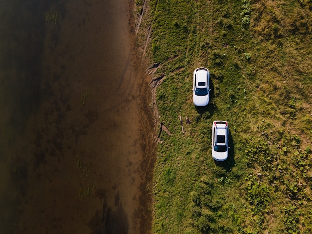 Luftaufnahme von Geländewagen am Flussstrand im Sommer