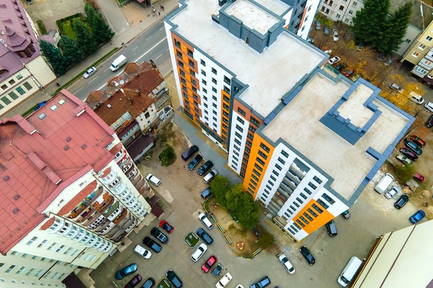 Luftaufnahme von geparkten Autos auf dem Parkplatz zwischen hohen Wohnhäusern.