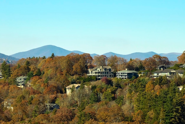 Luftaufnahme von großen Familienhäusern auf dem Berggipfel zwischen gelben Bäumen in der Vorstadt von North Carolina in der Herbstsaison Immobilienentwicklung in amerikanischen Vororten