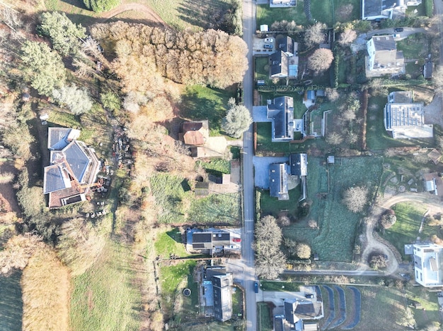 Luftaufnahme von Häusern, die von Wald und Ackerland umgeben sind, im ländlichen Gebiet von Wallonien, Belgien